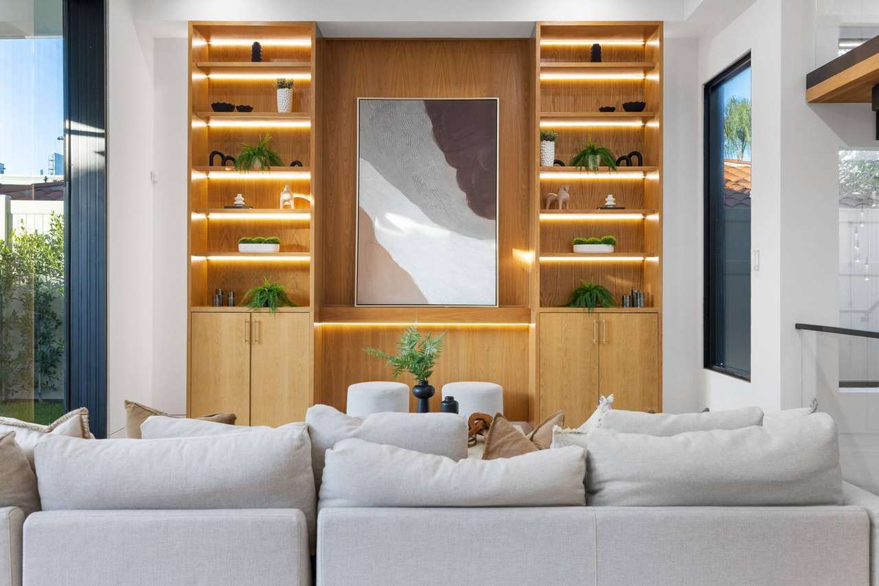 Illuminated living room built-in cabinetry and shelving by Millwork USA