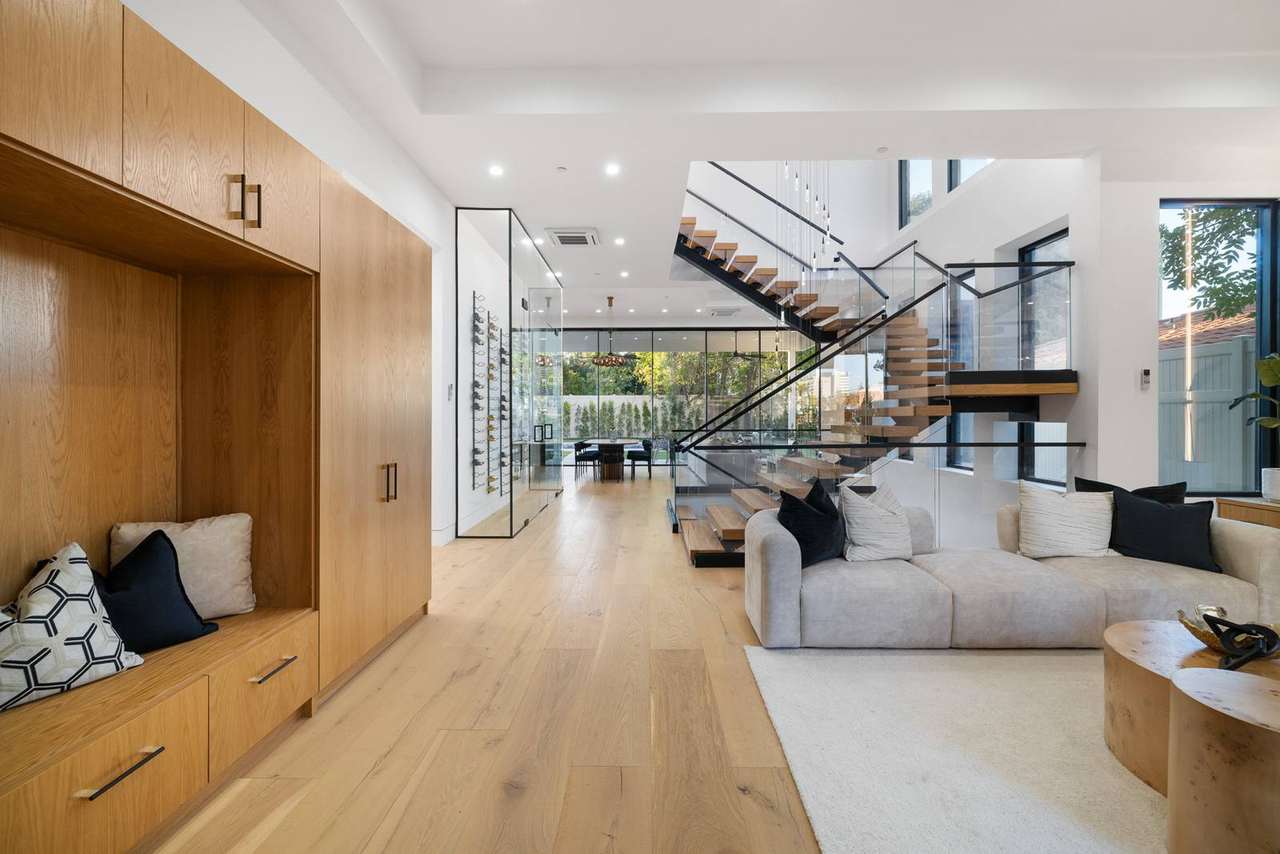 Custom integrated bench and cabinetry beside modern open stair
